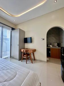 a bedroom with a bed and a desk and a television at Pondok Metis in Tumbak Bayuh