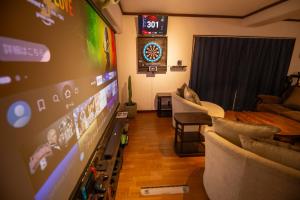 a living room with a flat screen tv and couches at CINEMA RESORTS 4 in Motobu