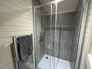 a shower with a glass door in a bathroom at 1 Bed in Betws-y-Coed 78677 in Capel Garmon