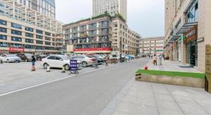 a city street with cars parked on the street at Xana Hotelle Chengdou Xindu Sanhechang Metro Station in Chengdu