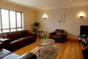 a living room with leather couches and a glass table at Oranhill Lodge Guesthouse in Oranmore