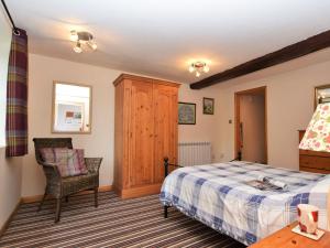un dormitorio con una cama y una silla en 1 Bed in Godshill IC146, en Godshill
