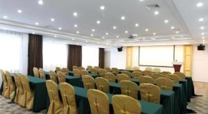 a conference room with green tables and chairs and a podium at City Comfort Inn Nanning Wuyi Fude in Nanning