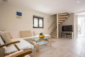 a living room with a couch and a tv and stairs at Galizana Peaceful Vacation home in Galižana