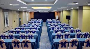 a conference room with blue and white chairs and a screen at Echarm Hotel Xian Ming City Wall South Gate in Xi'an