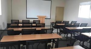 an empty classroom with tables and chairs and a screen at City Comfort Inn zhongshan Lihe Square Walmart in Zhongshan