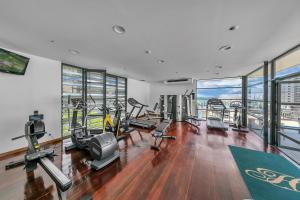 a gym with treadmills and ellipticals in a building at Modern Luxury Retreat with Rooftop Pool! in Auckland