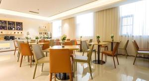 a restaurant with tables and chairs in a room at City Comfort Inn Nanning Taoyuan Road in Nanning