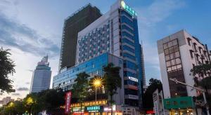 a tall building with a sign on it in a city at City Comfort Inn Nanning Taoyuan Road in Nanning