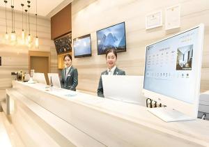 two men standing at a counter in a hotel lobby at City Comfort Inn Nanning Guangxi University for Nationalities in Nanning