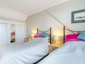two beds with pink and blue pillows in a bedroom at 3 Bed in Porthtowan 90556 in Porthtowan