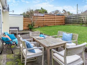 a patio with a wooden table and chairs at 3 Bed in Porthtowan 90556 in Porthtowan