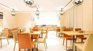 a dining room with tables and chairs and a window at City Comfort Inn Nanning Guangxi University for Nationalities in Nanning