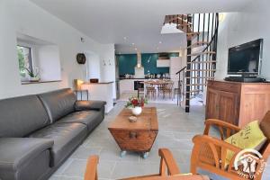 een woonkamer met een bank, een tv en een tafel bij Rumedon in Ploumilliau