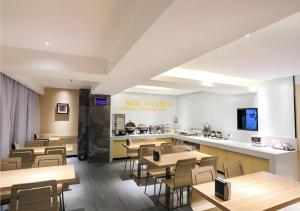a restaurant with tables and chairs and a counter at City Comfort Inn Chengdu Giant Panda Base in Chengdu