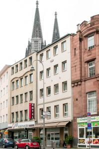 een gebouw op de hoek van een straat met gebouwen bij Hotel Sandmanns am Dom in Keulen