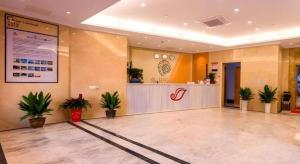 a lobby of a hospital with a counter and plants at Shell Hotel Changzhou North Railway Station Global Harbor Metro Station in Changzhou