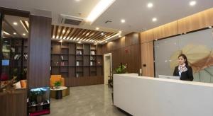 a woman standing behind a counter in a lobby at GreenTree Inn Express Shandong Zaozhuang Shizhong District Huashan Road Ginza in Zaozhuang