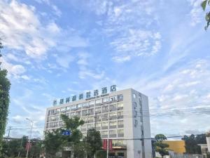 a white building with a sign on top of it at GreenTree Inn Express Guangxi Nanning Mingyang Avenue Nanning Airport in Nanning
