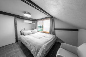 a small bedroom with a bed and a window at Akatsuki in Kami-furano