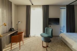 ein Hotelzimmer mit einem Bett und zwei Stühlen in der Unterkunft Hotel Meteo Kakheti in Telawi