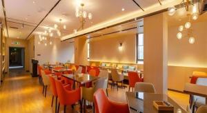 a restaurant with tables and chairs in a room at Echarm Hotel Hefei West Qilitang Metro Station in Hefei