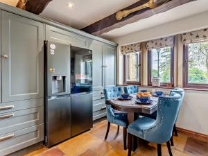 a kitchen with a wooden table and blue chairs at 8 Bed in Pateley Bridge 95111 in Sawley