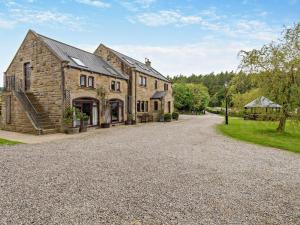 a large stone house with a gravel driveway at 8 Bed in Pateley Bridge 95111 in Sawley
