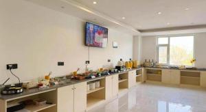 a large white kitchen with a large counter top at GEM Hotel Zibo Economic Development Zone Zibo Vocational Institute in Jinan