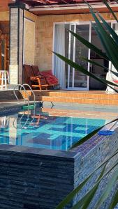 una piscina con una mesa y una silla en una casa en As Family Villa, en Singaraja