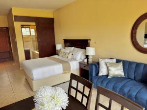 a bedroom with a bed and a blue couch at Ocean View Villa Studio Apartment A01 in Port Edward