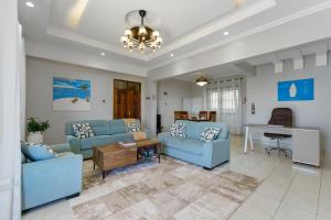 Una sala de estar con sofás azules y una mesa. en Zuri's Luxurious Oceanview Penthouse, Meters from the beach, en Shanzu