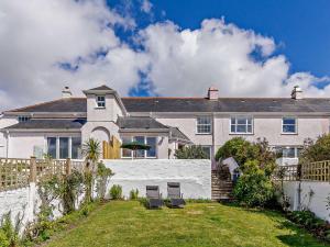a house with two chairs in the yard at 3 Bed in Saint Just in Roseland 81488 in Saint Just in Roseland
