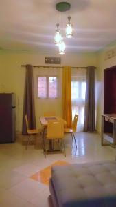 een woonkamer met een tafel en gele stoelen bij Home sweet Home in Entebbe