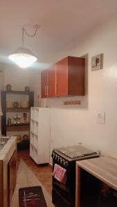 een keuken met een fornuis en een witte koelkast bij Home sweet Home in Entebbe
