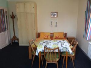 a dining room with a table and chairs and a bed at Apartmány Mikeš in Kašperské Hory