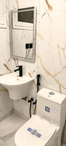 a white bathroom with a sink and a toilet at قمة قباءلشقق in Al Madinah +3 photos