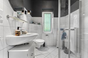 a bathroom with a sink and a toilet and a shower at Villa Wilma Hinte in Suurhusen +24 photos