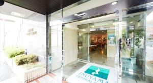 a glass building with a sign on the front of it at Inuyama Central Hotel in Haguro