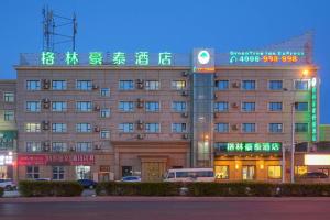a building with neon signs on the front of it at Green Tree Inn Urumqi San'gong Metro Station Exit in Ürümqi
