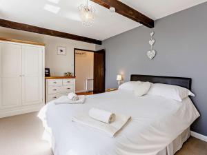 ダルバートンにある1 Bed in Dulverton LBARDのタオルが敷かれた大きな白いベッドのある寝室