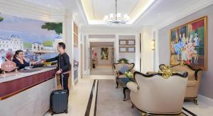 a man and woman standing at a bar in a hotel lobby at Vienna Hotel Chengdu Exhibition Center In Time City in Chengdu