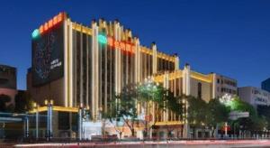 a large building is lit up at night at Vienna Hotel Kunming Beijing Road Chuanxin Gulou Metro Station in Kunming