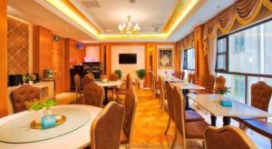 a restaurant with tables and chairs in a room at Vienna Hotel Kunming Beijing Road Chuanxin Gulou Metro Station in Kunming