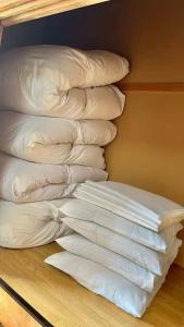 a pile of white pillows sitting on a wooden floor at 苗場ウッドインだいまる in Yuzawa +6 photos