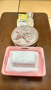 a pink tray with a towel on a table at 苗場ウッドインだいまる in Yuzawa