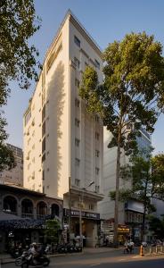 a tall white building on a city street at Asian Ruby Hotel & Spa - 122F Bui Thi Xuân Street in Ho Chi Minh City