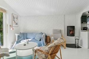 a living room with a blue couch and a table at Cosy Summerhouse With Private Garden in Nyrup