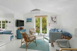 a living room with a couch and a table at Cosy Summerhouse With Private Garden in Nyrup