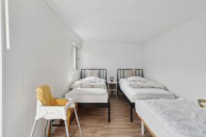 a room with three beds and a chair at Cosy Summerhouse With Private Garden in Nyrup